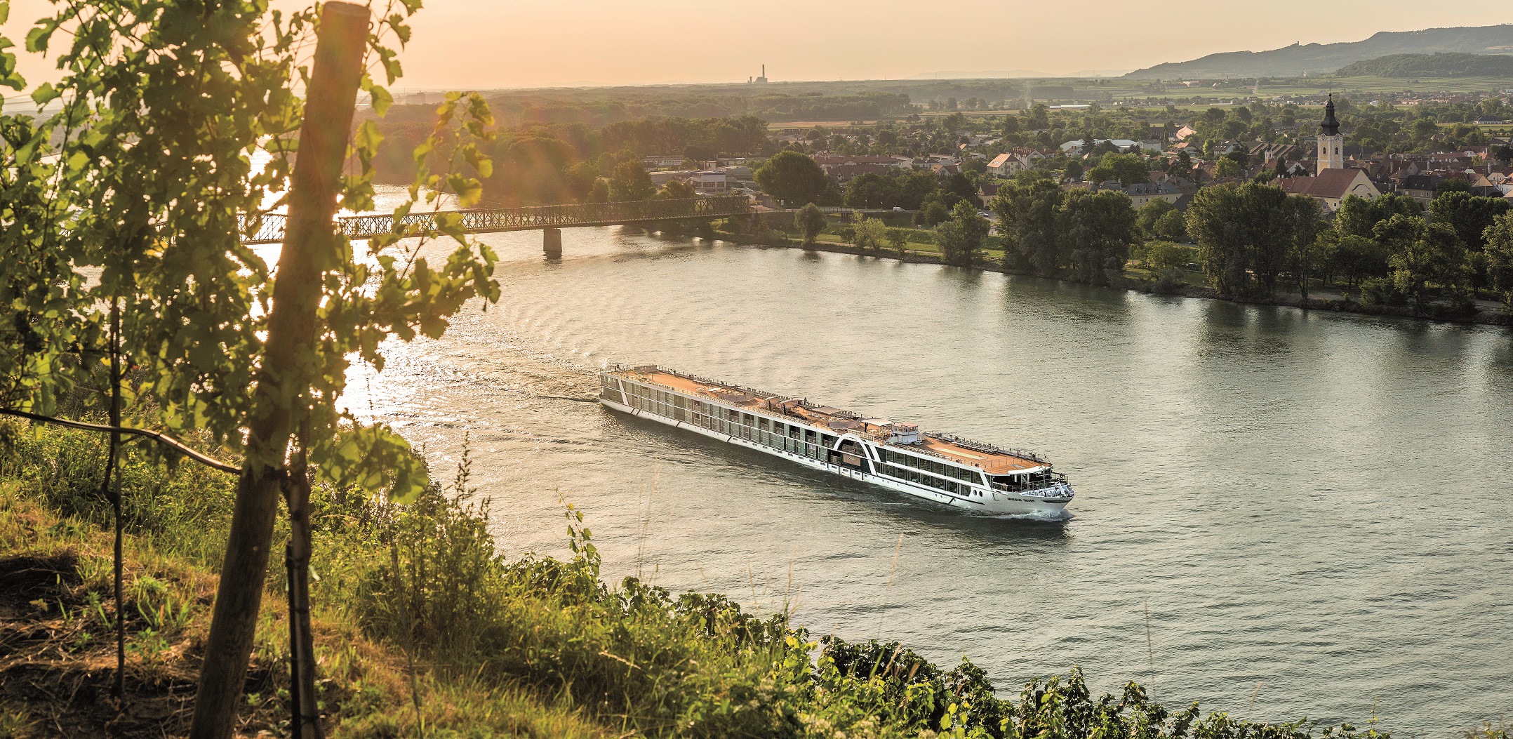Amadeus River Ship floating on river with European village in background